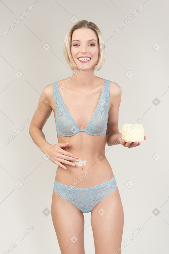 그녀의 뱃속에 바디 크림을 적용 섹시 한 젊은 여자