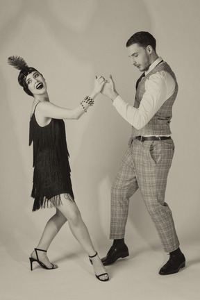 Excited young couple performing charleston dance