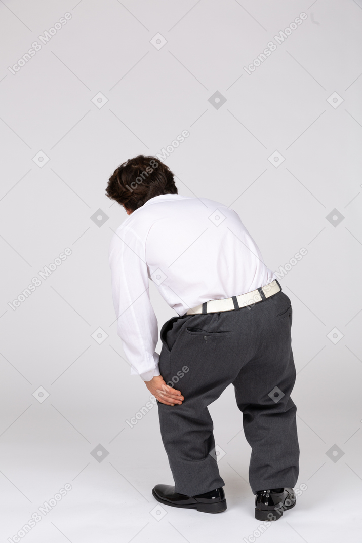 Rear view of man groaning with pain in leg