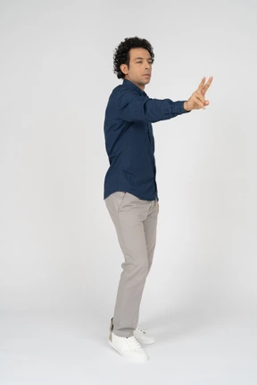 Vista frontal, de, un, hombre, en, ropa informal, actuación, señal v