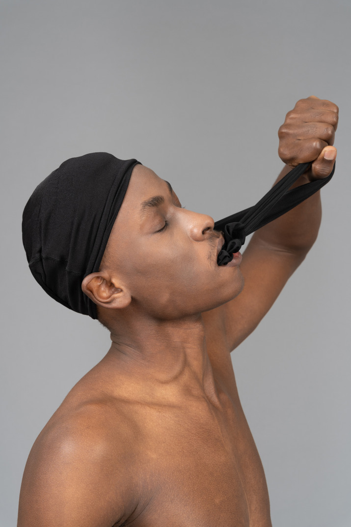 Young man pulling out tights from his mouth