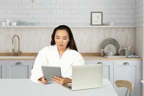 Woman in bathrobe using tablet