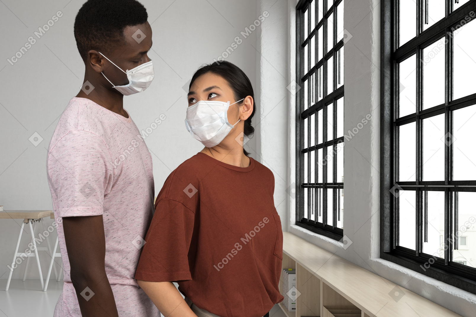 A man and a woman wearing face masks and looking at each other