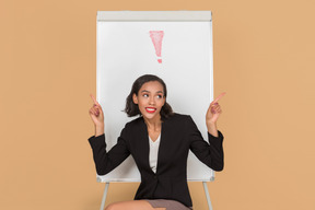 Jolie femme afro assis devant le tableau blanc