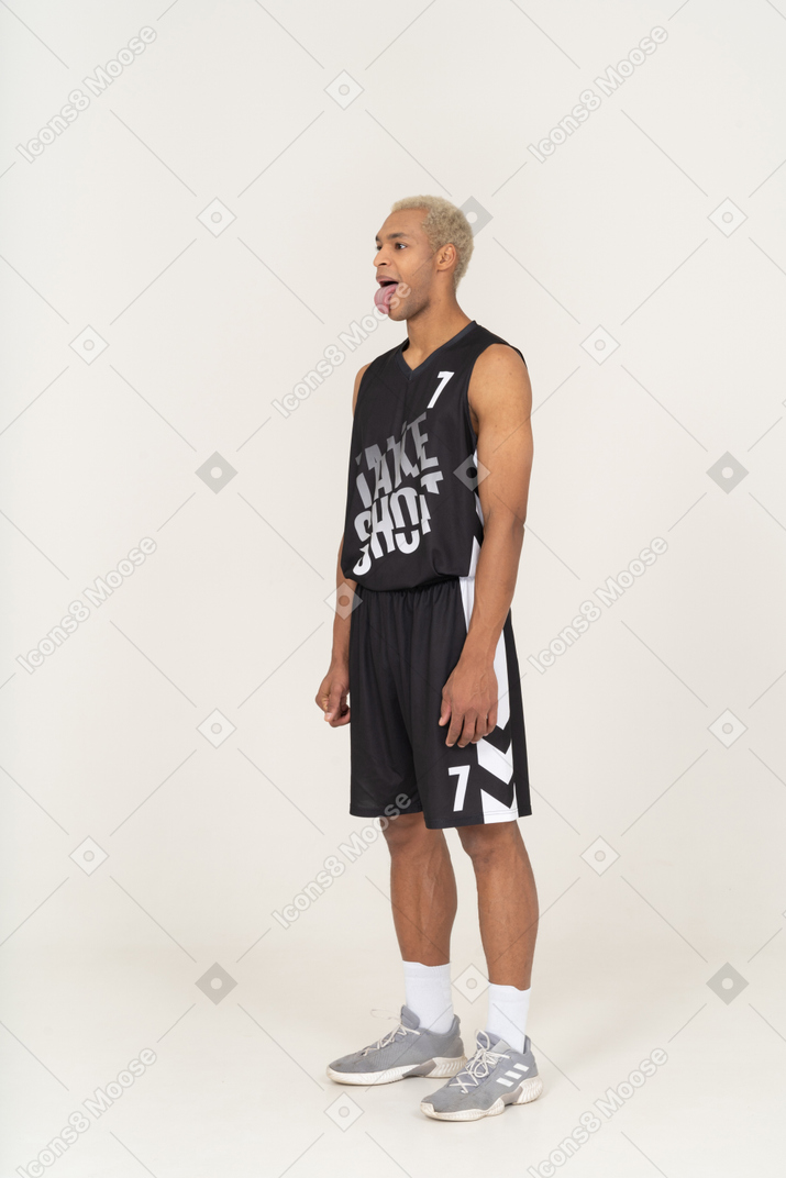 一个疯狂的年轻男篮球运动员展示舌头的四分之三视图