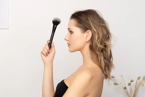 Vista lateral, de, un, sensual, mujer joven, tenencia, un, cepillo de maquillaje