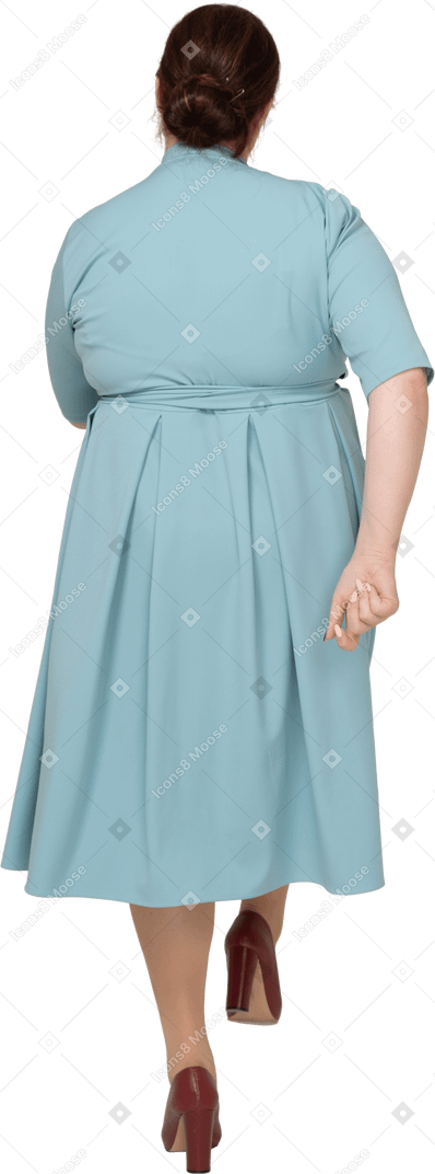 Vista posteriore di una donna in abito blu che cammina