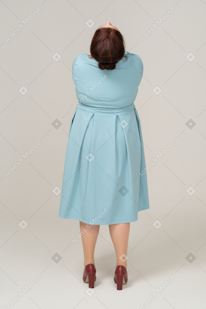 一个穿着蓝色连衣裙的女人仰望的后视图