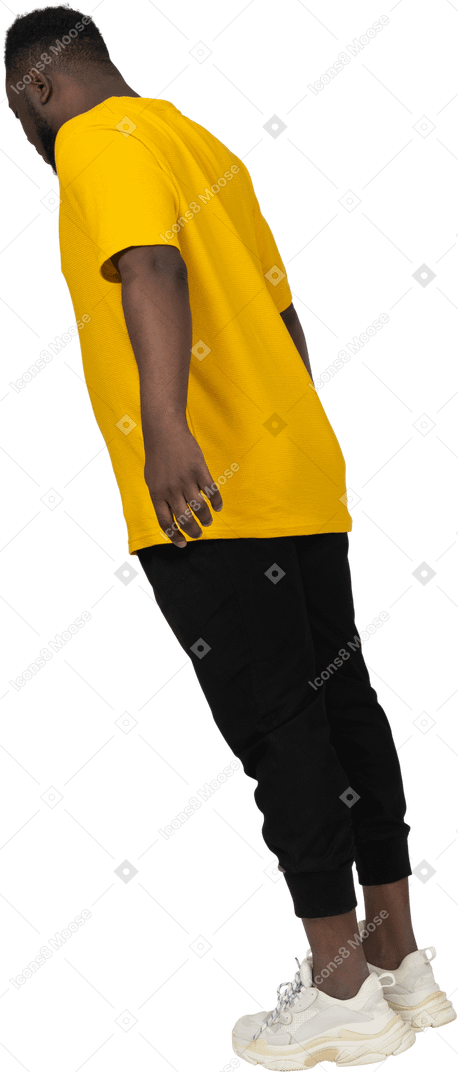 Vista posteriore di tre quarti di un giovane uomo dalla pelle scura in maglietta gialla proteso in avanti e braccio teso