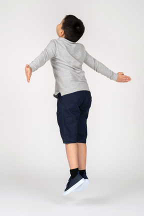 Мальчик прыгает с раскинутыми руками