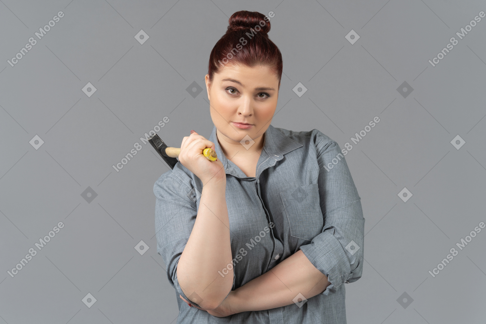 Frau, die skeptisch in die kamera schaut und einen hammer hält