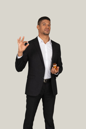 African american man in black suit holding pills