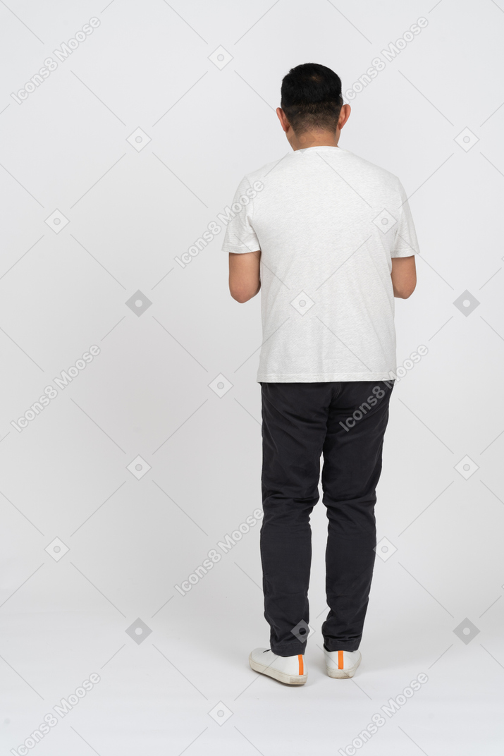 Back view of a man in casual clothes plotting something