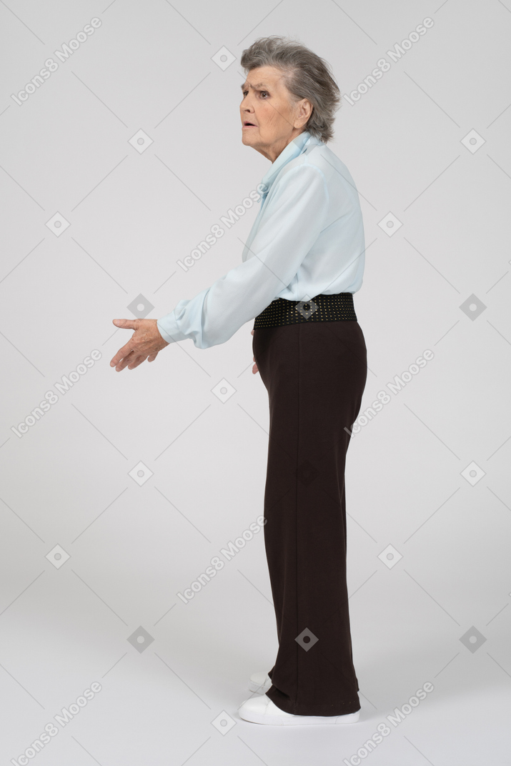 Vista laterale di una donna anziana che gesticola in modo interrogativo