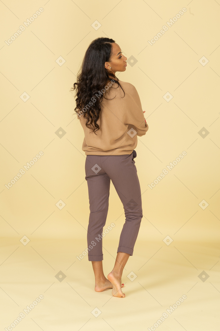 若い浅黒い肌の女性の交差する腕の背面図