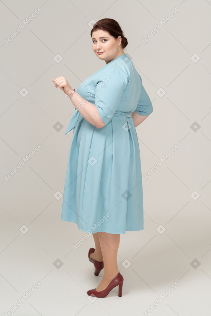 一个穿着蓝色裙子的快乐女人的侧视图