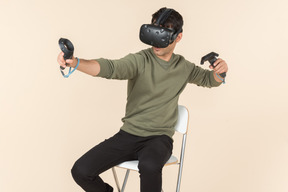 Молодой кавказский парень играет в игру виртуальной реальности