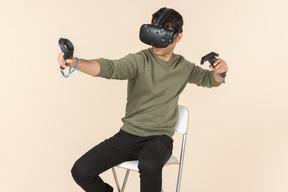 Young caucasian guy playing a virtual reality game