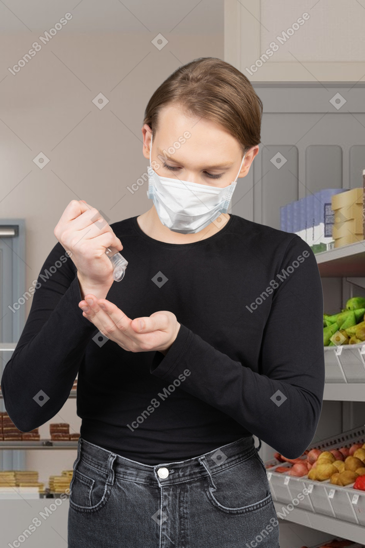 Мужчина использует дезинфицирующее средство для рук в магазине