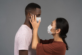 Um jovem casal usando máscaras faciais