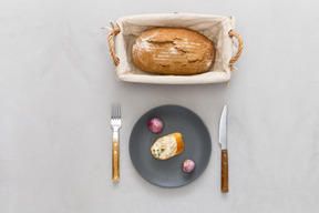 Piece of bread, cutlery  and garlic bread