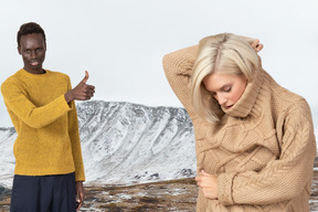 Donna in maglione caldo e uomo che mostra i pollici in su