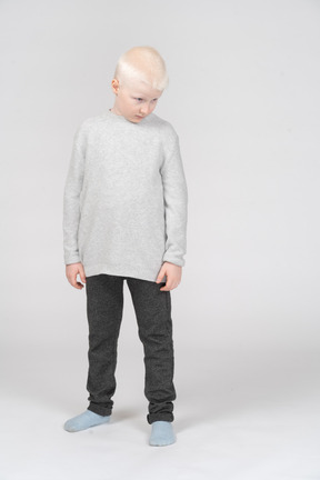 Front view of a shy little boy in casual clothes