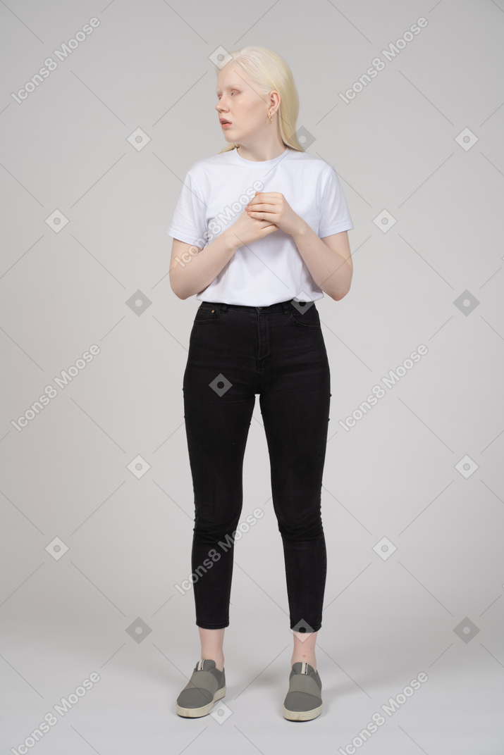 Vista frontal de una mujer joven con ropa informal mirando hacia otro lado