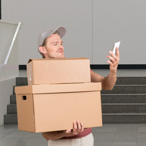 A man holding a box and a cell phone