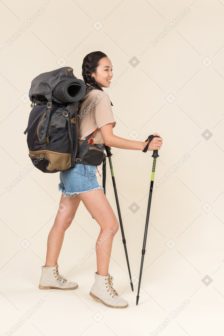 Donna escursionista in piedi con bastoncini da trekking