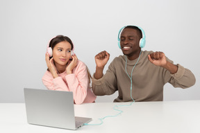 Atractiva pareja escuchando música en auriculares.