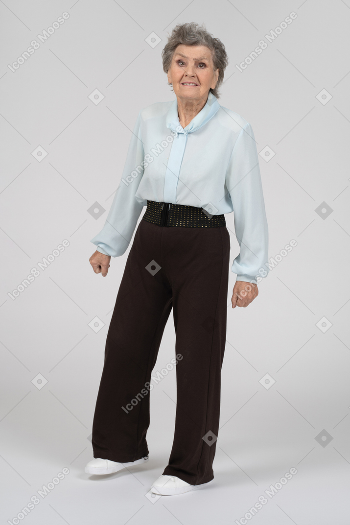 Vista frontal de una anciana haciendo una mueca con una sonrisa