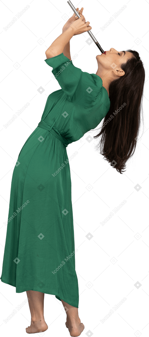 Вид сбоку на девушку в зеленом платье, играющую на флейте, откинувшись назад