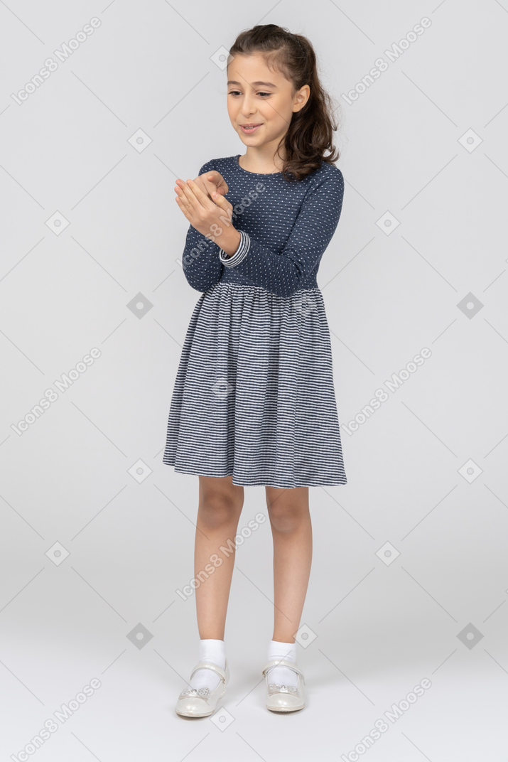 Three-quarter view of a girl pointing at her palm