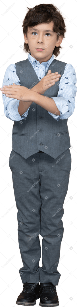 停止ジェスチャーを示す灰色のスーツを着た少年の正面図