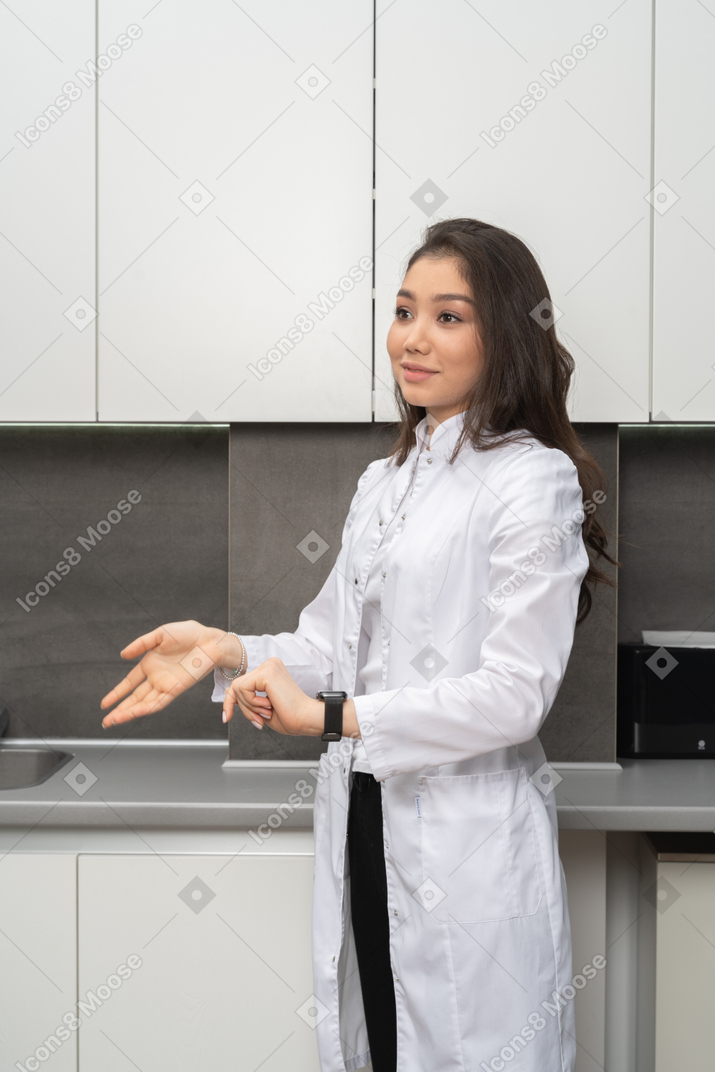 Smiling female nurse gesticulating and smiling lightly