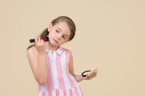 Cute little girl applying makeup