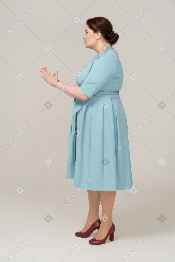 站在侧面的蓝色连衣裙的女人