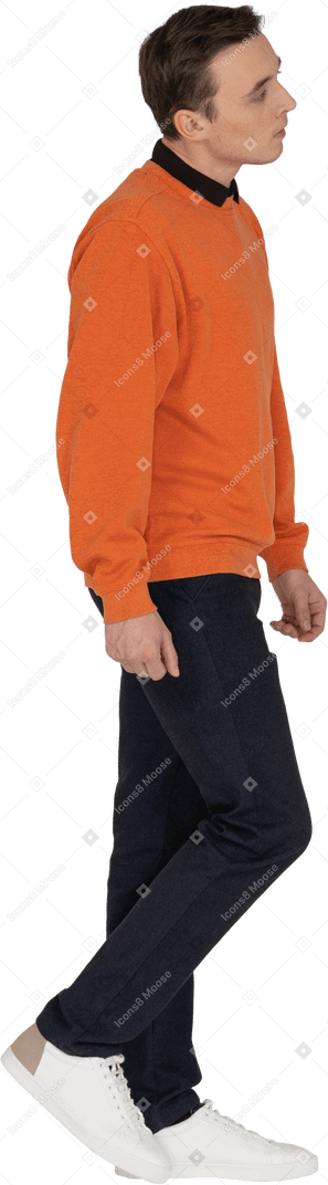 Молодой человек в оранжевой толстовке гуляет