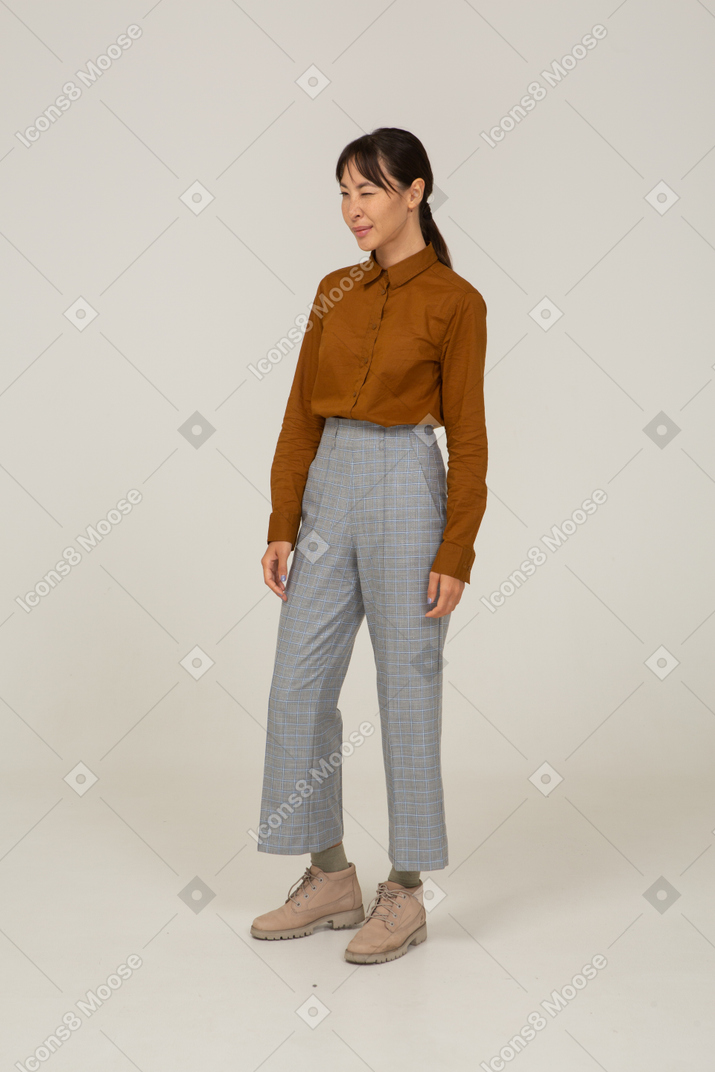 Three-quarter view of a winking young asian female in breeches and blouse