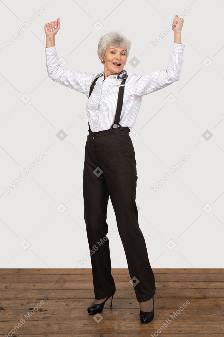 Formally dressed woman celebrating with her hands up