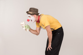 Bend male clown holding toy turtle