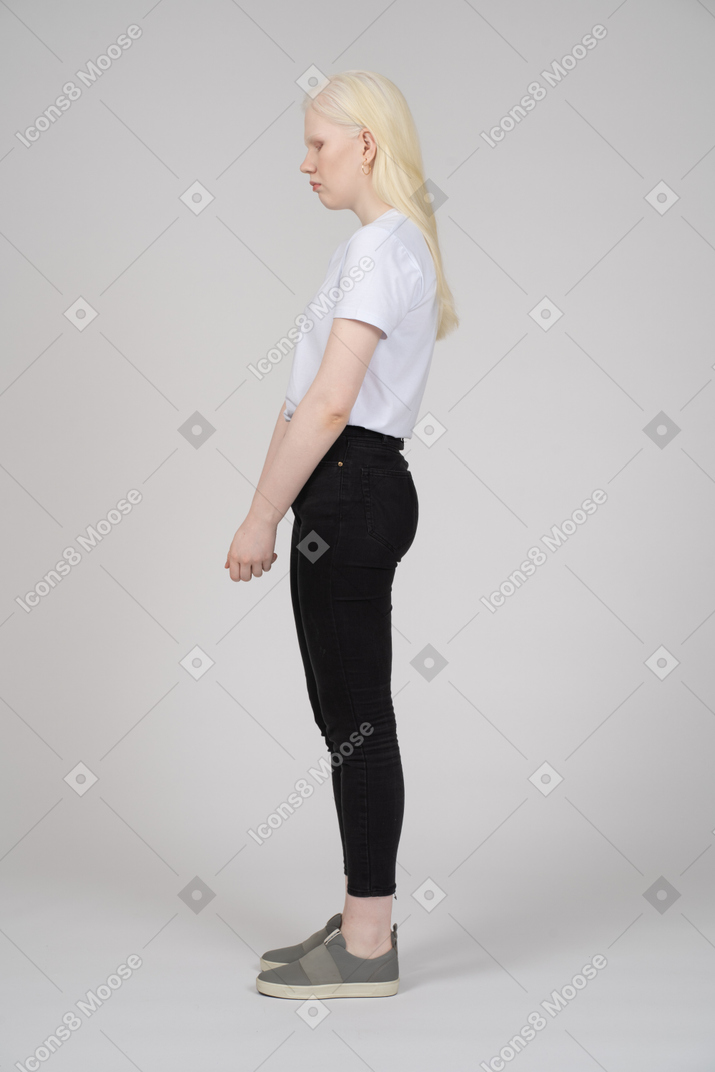 Side view of a young woman in casual clothes looking down