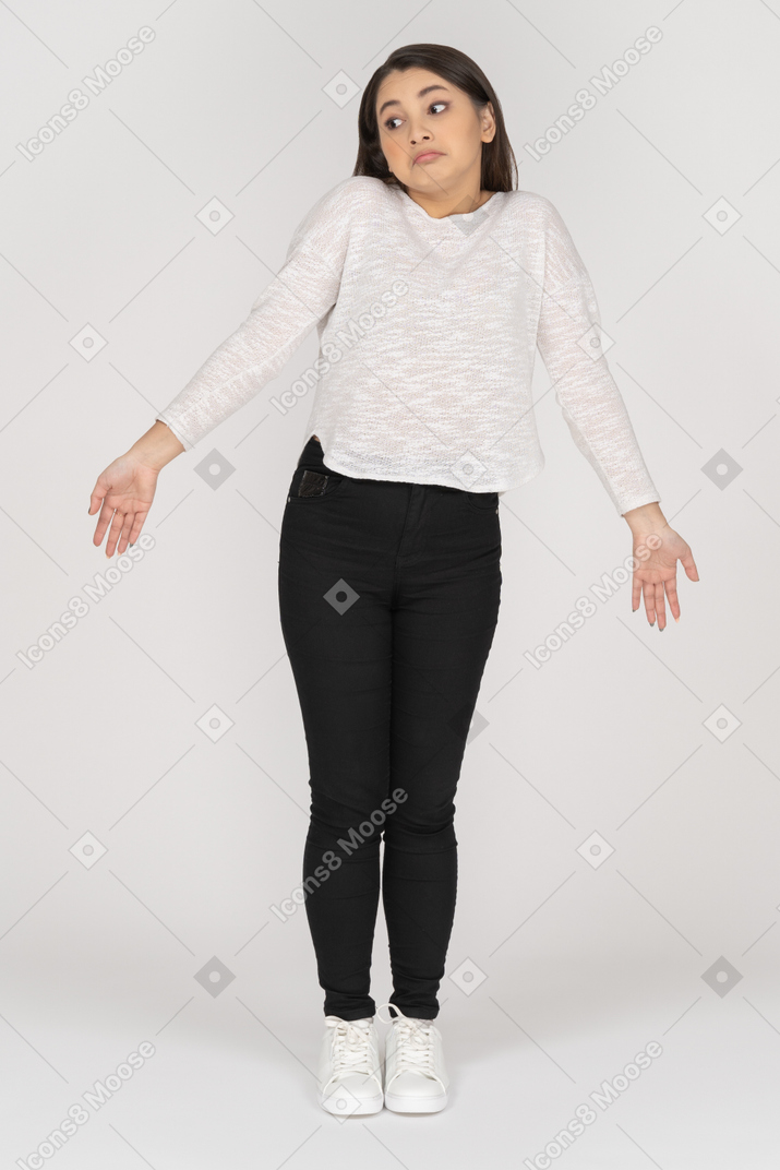 Front view of a unaware young indian female in casual clothing outspreading arms
