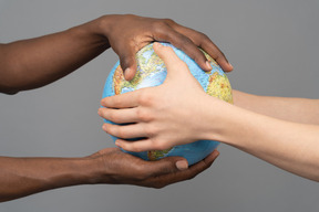 Mãos diferentes, segurando o globo da terra