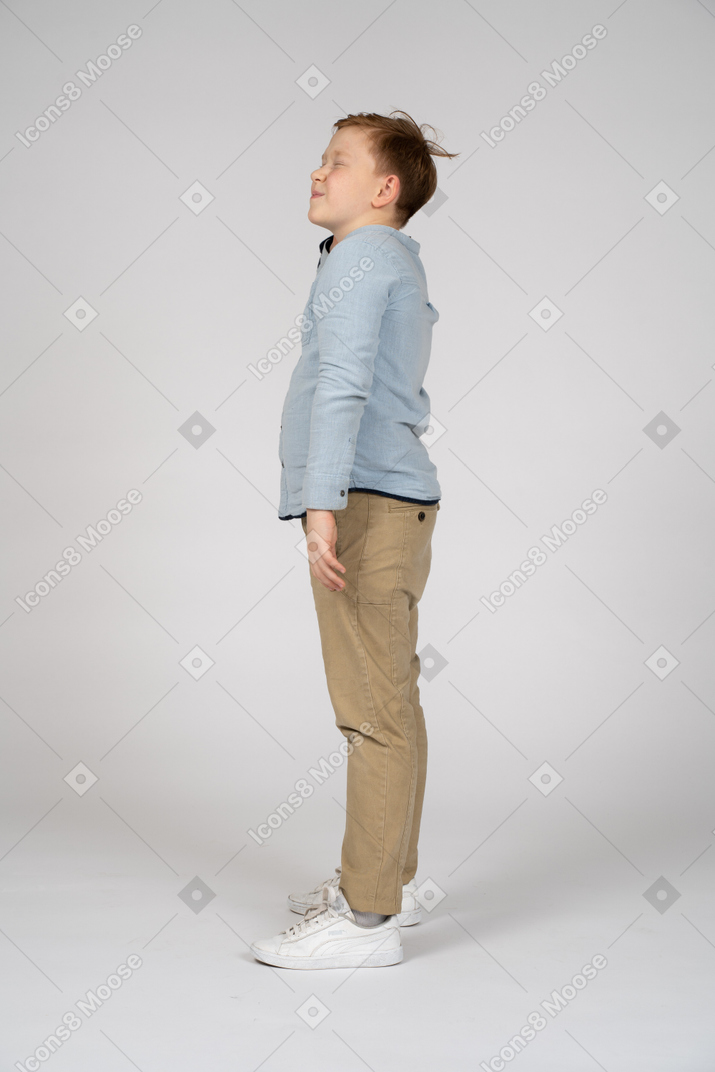 Side view of a boy scratching head
