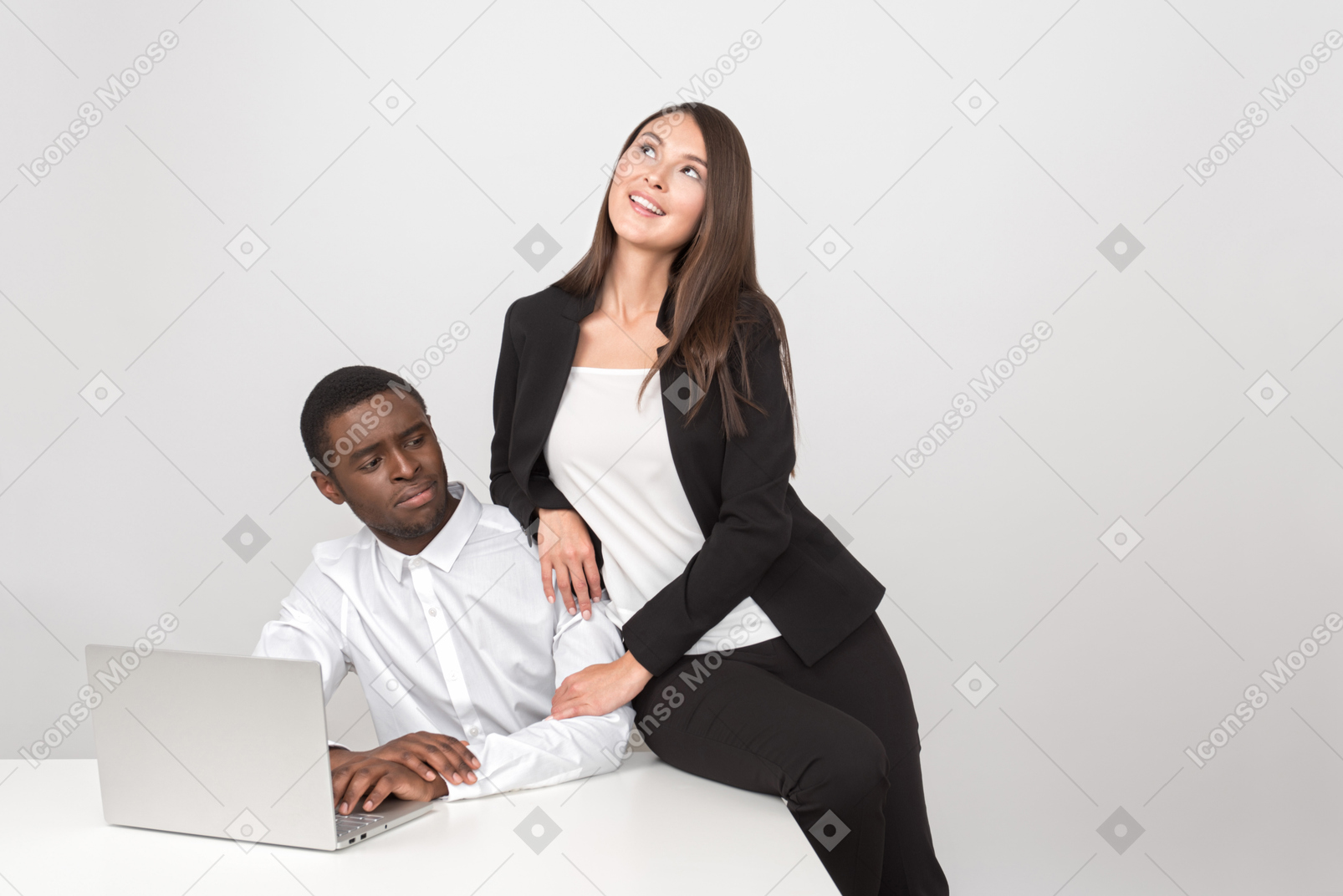 Donna asiatica attraente che abbraccia il suo collega stupito sul posto di lavoro