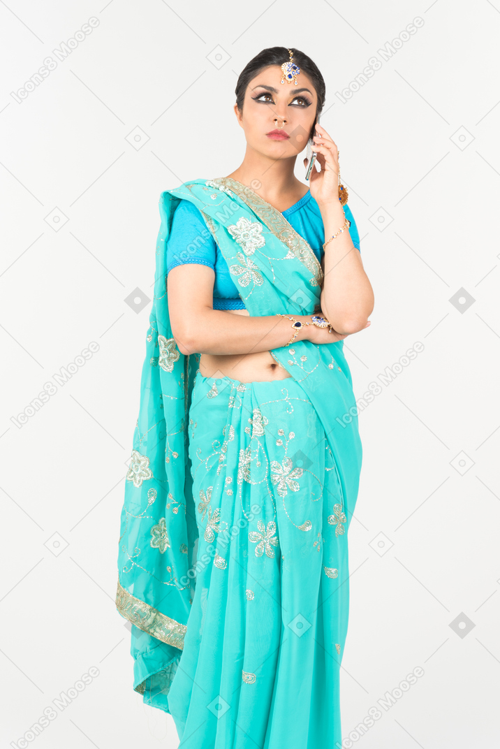 Serious looking young indian dancer talking on the phone