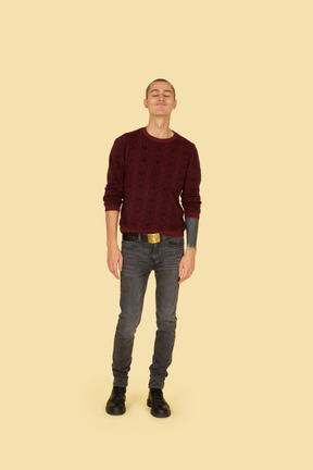Front view of a funny grimacing young man in read sweater