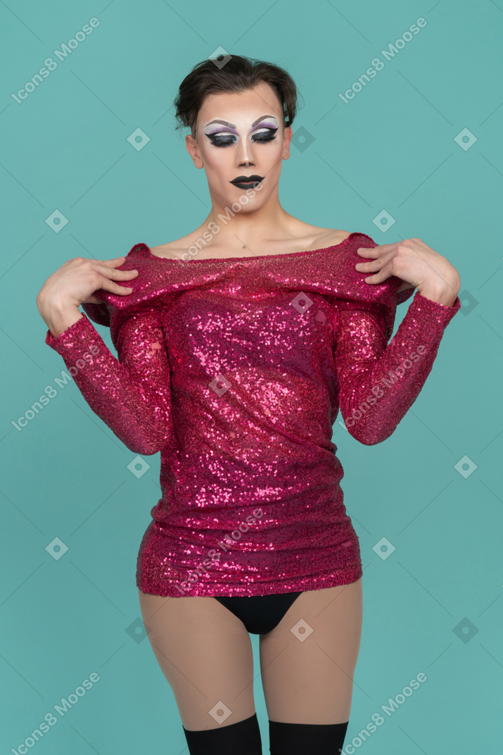 Front view of a drag queen in stage make-up undressing